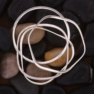Silver bracelets on river rock