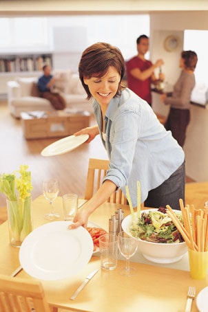 Dans la salle à manger, elle met la table