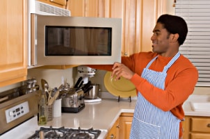 Man taking food out of a microwave