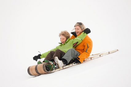 Mother and son sledding together