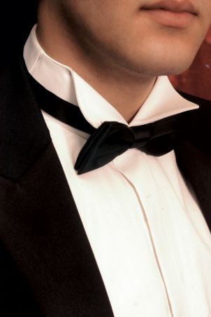 Man wearing a tuxedo shirt and a black tuxedo
