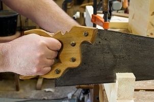 Man using a saw on a woodworking bench