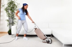 A woman using an upright vacuum