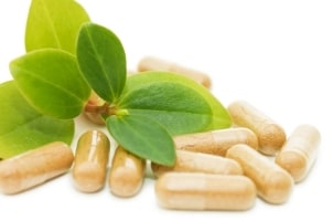Dietary supplements on a table next to leaves