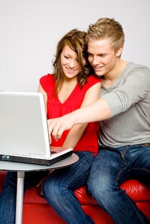 A young engaged couple learns about titanium wedding rings online before 