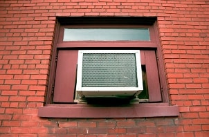 Air conditioner in a window of a red brick building