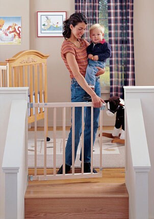 Child Safety Gate on Cute Baby Boy With His Mom In Front Of A Safety Gate