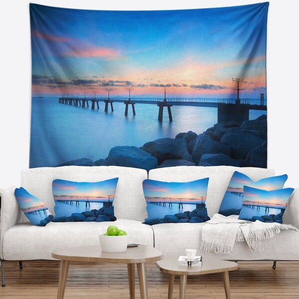 Designart 'Bluish Rocky Seashore with Pier' Sea Bridge Wall Tapestry