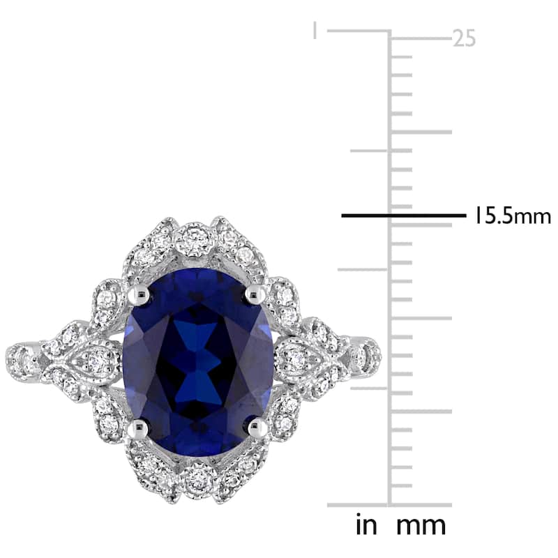 Miadora 10k White Gold Created Blue Sapphire and 1/5ct TDW Diamond Vintage Halo Cocktail Ring