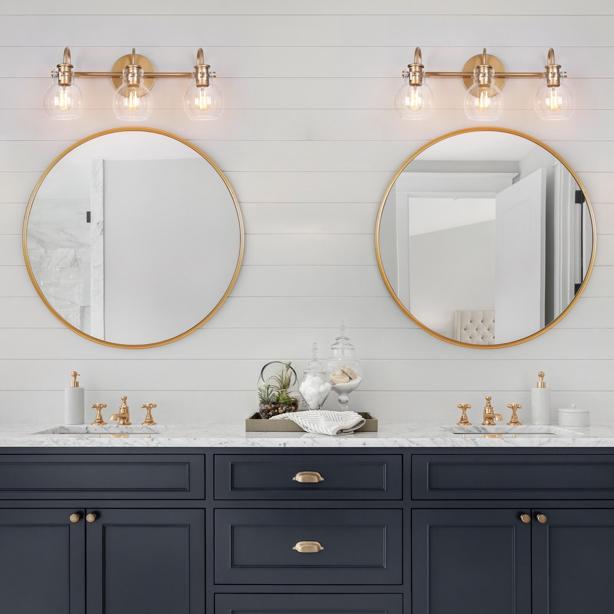 Twin gold bathroom sconces installed above the mirrors.