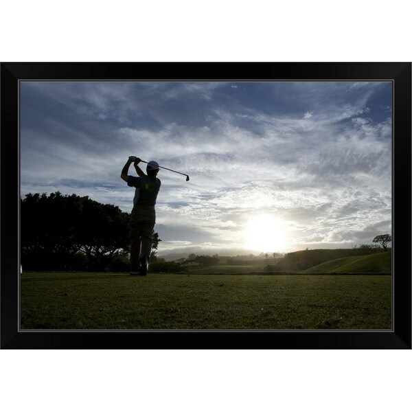 "Mature man swinging golf club at dusk" Black Framed Print