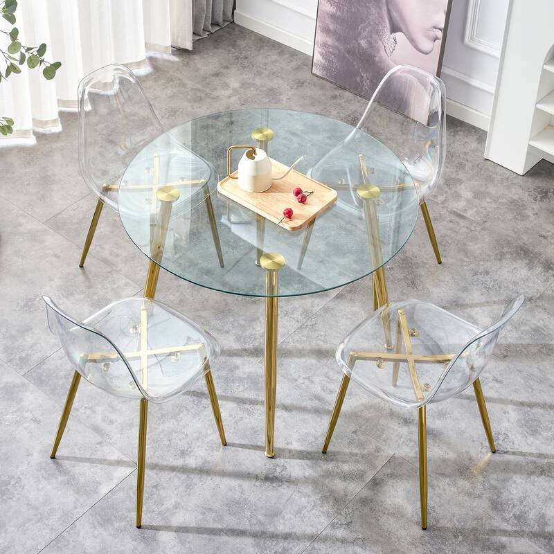 A glass tabletop with a diameter of 40 inches and a modern minimalist circular dining table with gold plated metal legs.