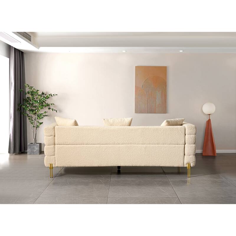 Luxurious and comfortable upholstered sofa with golden legs and pillows for living room and reception area