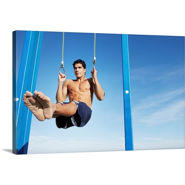 "Man on a beach working out on exercise rings apparatus" Canvas Wall Art