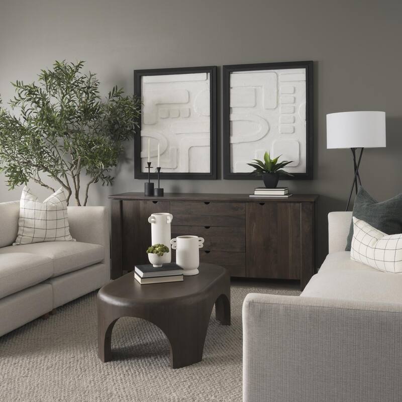 The Shima Coffee Table is a smooth, dark matte brown oval coffee table with curved edges and arched cut out legs.