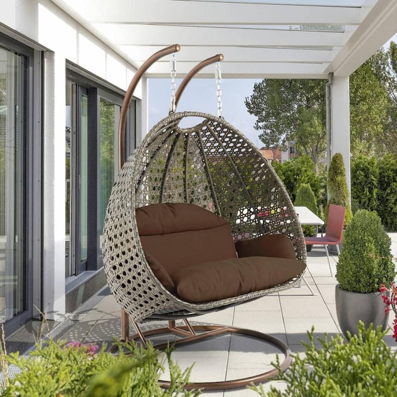 LeisureMod 2-Person Hanging Egg Swing Chair with Metal Stand - Handcrafted Beige Wicker, Patio Hammock Lounger with Cushions