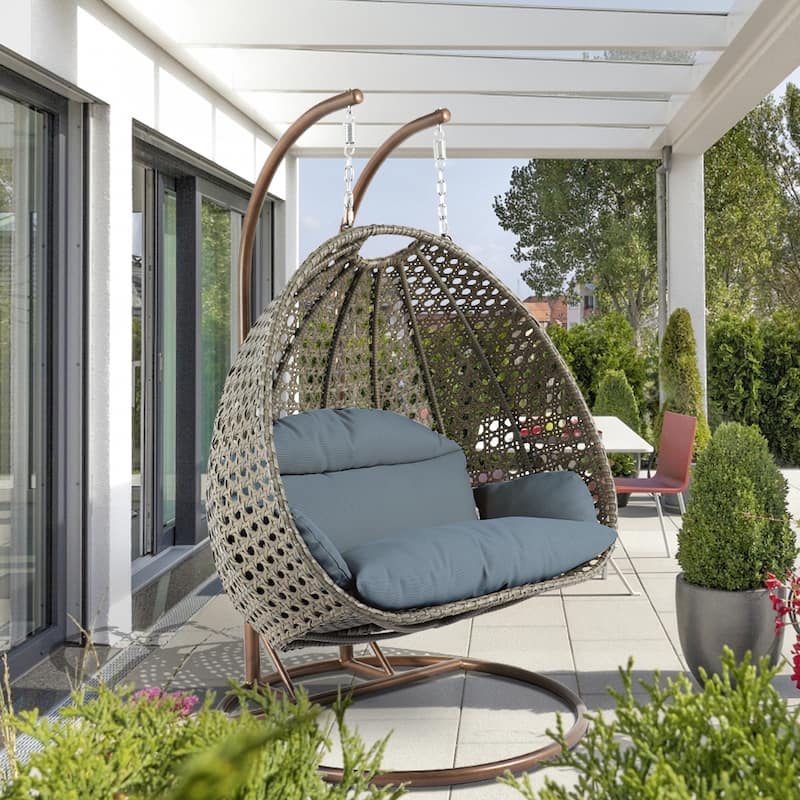 LeisureMod 2-Person Hanging Egg Swing Chair with Metal Stand - Handcrafted Beige Wicker, Patio Hammock Lounger with Cushions - Charcoal Blue