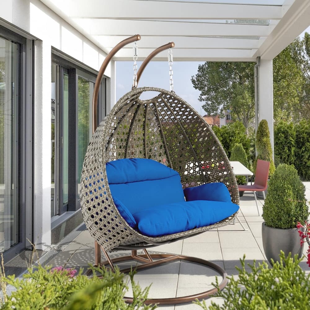 LeisureMod 2-Person Hanging Egg Swing Chair with Metal Stand - Handcrafted Beige Wicker, Patio Hammock Lounger with Cushions