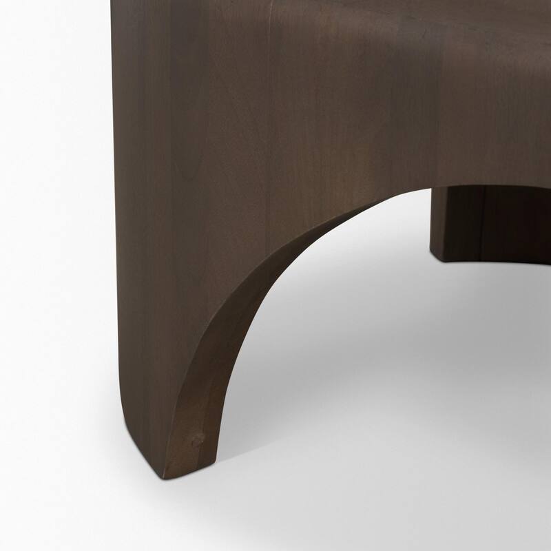 The Shima Coffee Table is a smooth, dark matte brown oval coffee table with curved edges and arched cut out legs.