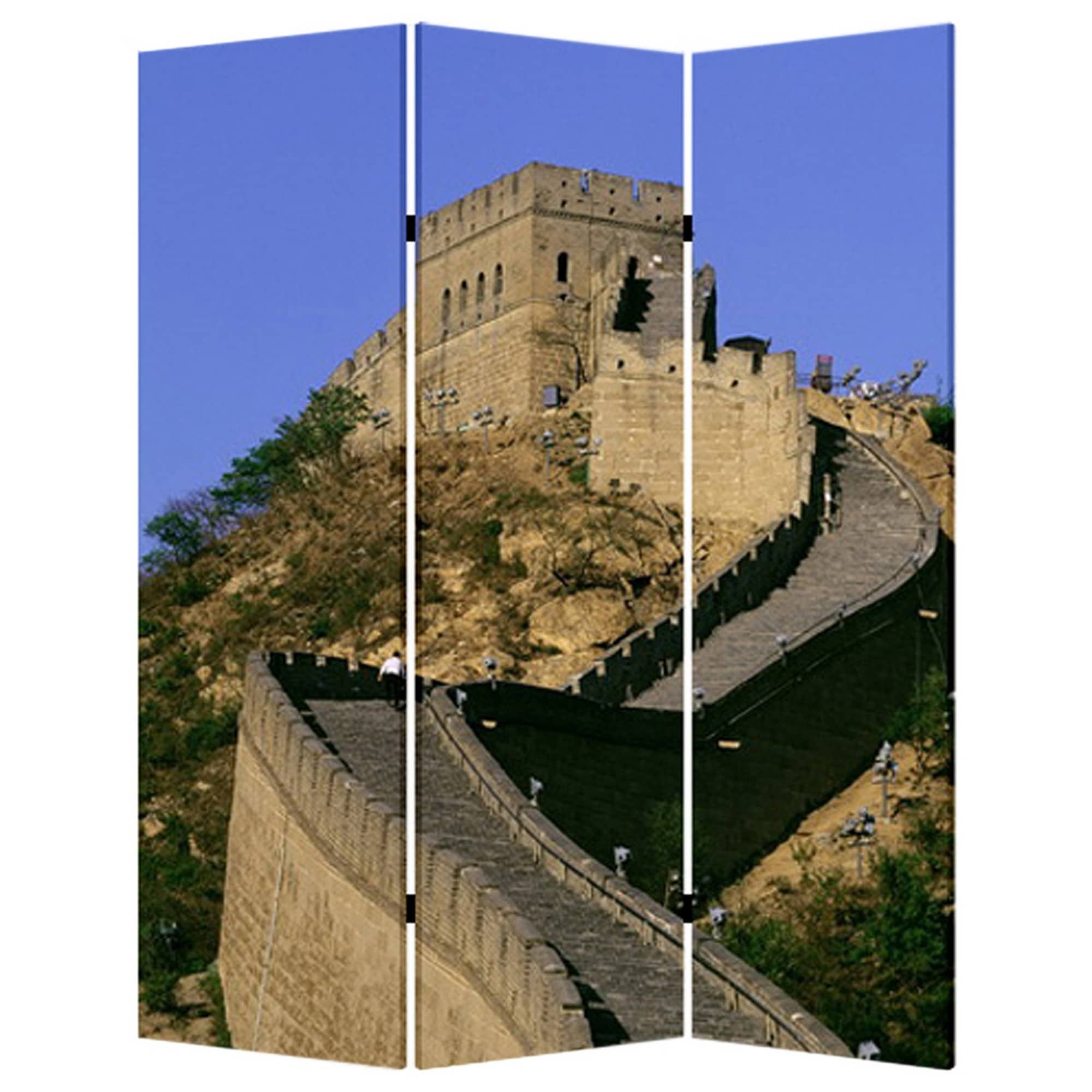 A three-panel folding room divider featuring a scenic photo of the Great Wall of China displayed across all panels, set in a living room with a beige armchair, blue cushion, floor lamp, books, and a woven pouf.