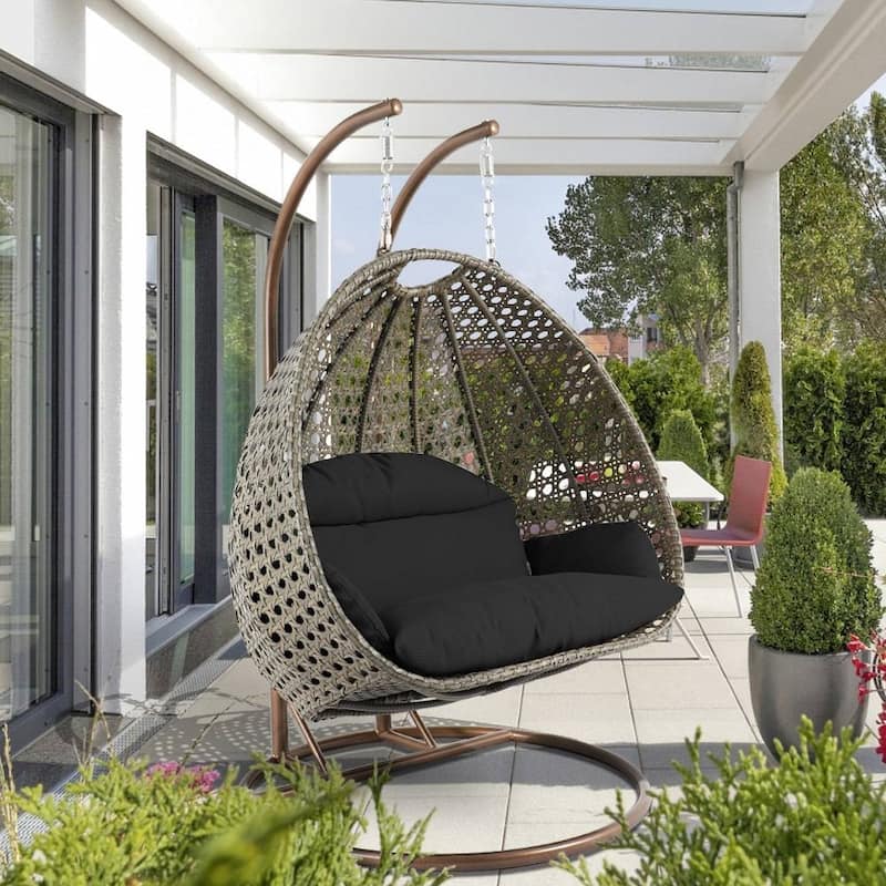LeisureMod 2-Person Hanging Egg Swing Chair with Metal Stand - Handcrafted Beige Wicker, Patio Hammock Lounger with Cushions - Black