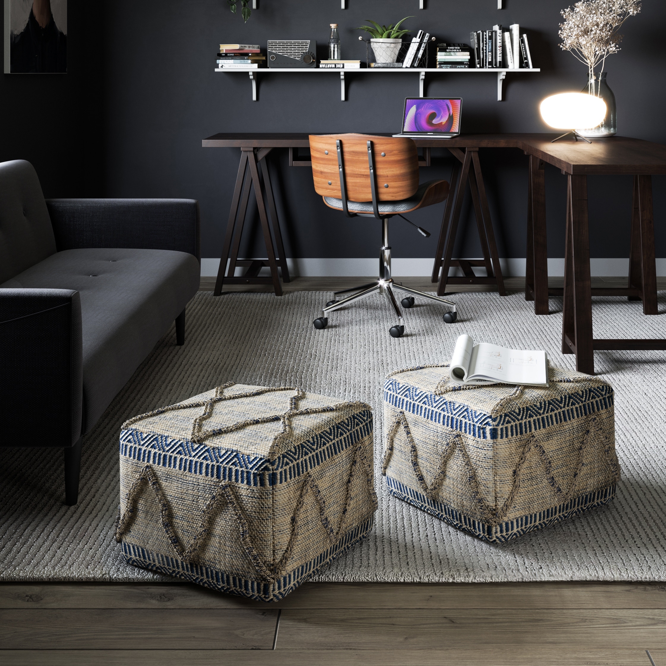 Patterned woven ottoman pouf with geometric zigzag embroidery in beige and gray, placed in contemporary living room setting with a wooden side table