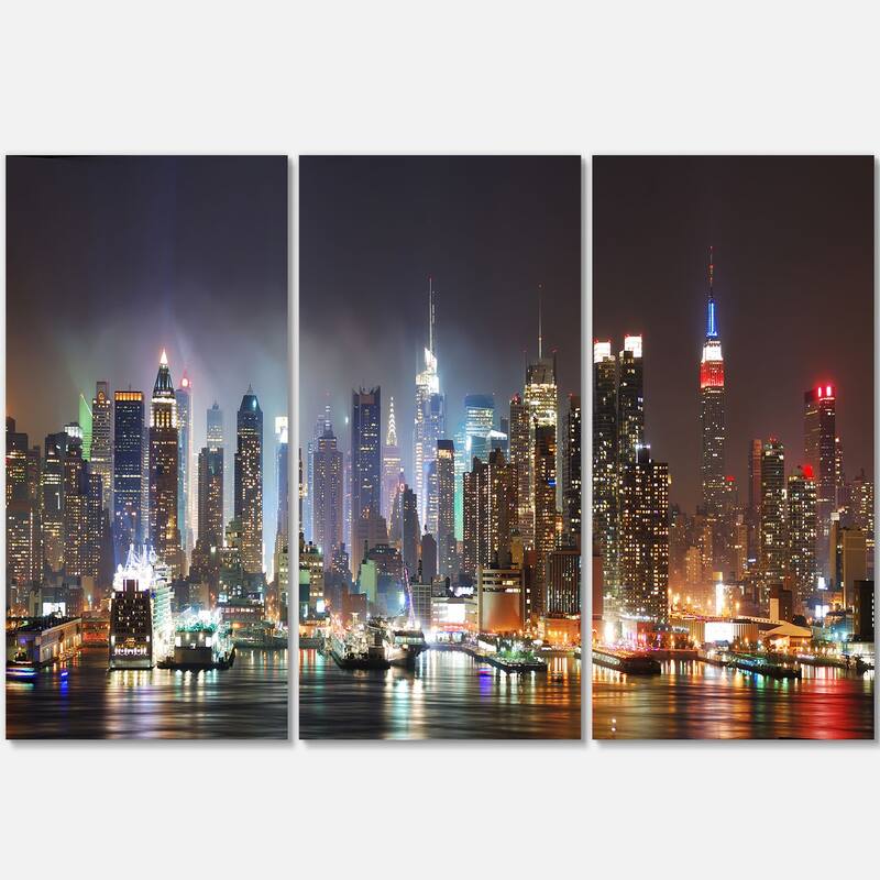 Designart 'Lit NYC Manhattan Skyline' Cityscape Photo Metal Wall Art - 36 in. wide x 28 in. high - 3 panels
