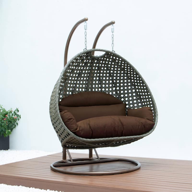 LeisureMod 2-Person Hanging Egg Swing Chair with Metal Stand - Handcrafted Beige Wicker, Patio Hammock Lounger with Cushions