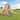 Kids Outdoor Wooden Swing Set with Elevated Playhouse, Wave Slide, Belt Swings and Sandbox - Natural Wood