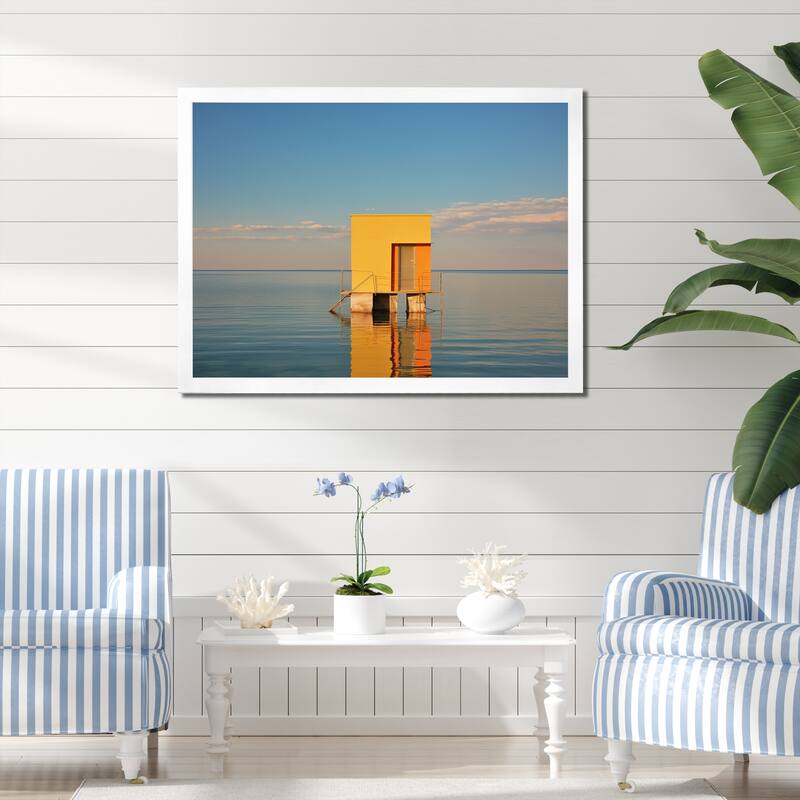 Designart "Coastal Minimalism Yellow Building In The Water I" Beach Framed Canvas Prints - 44 in. wide x 34 in. high - White
