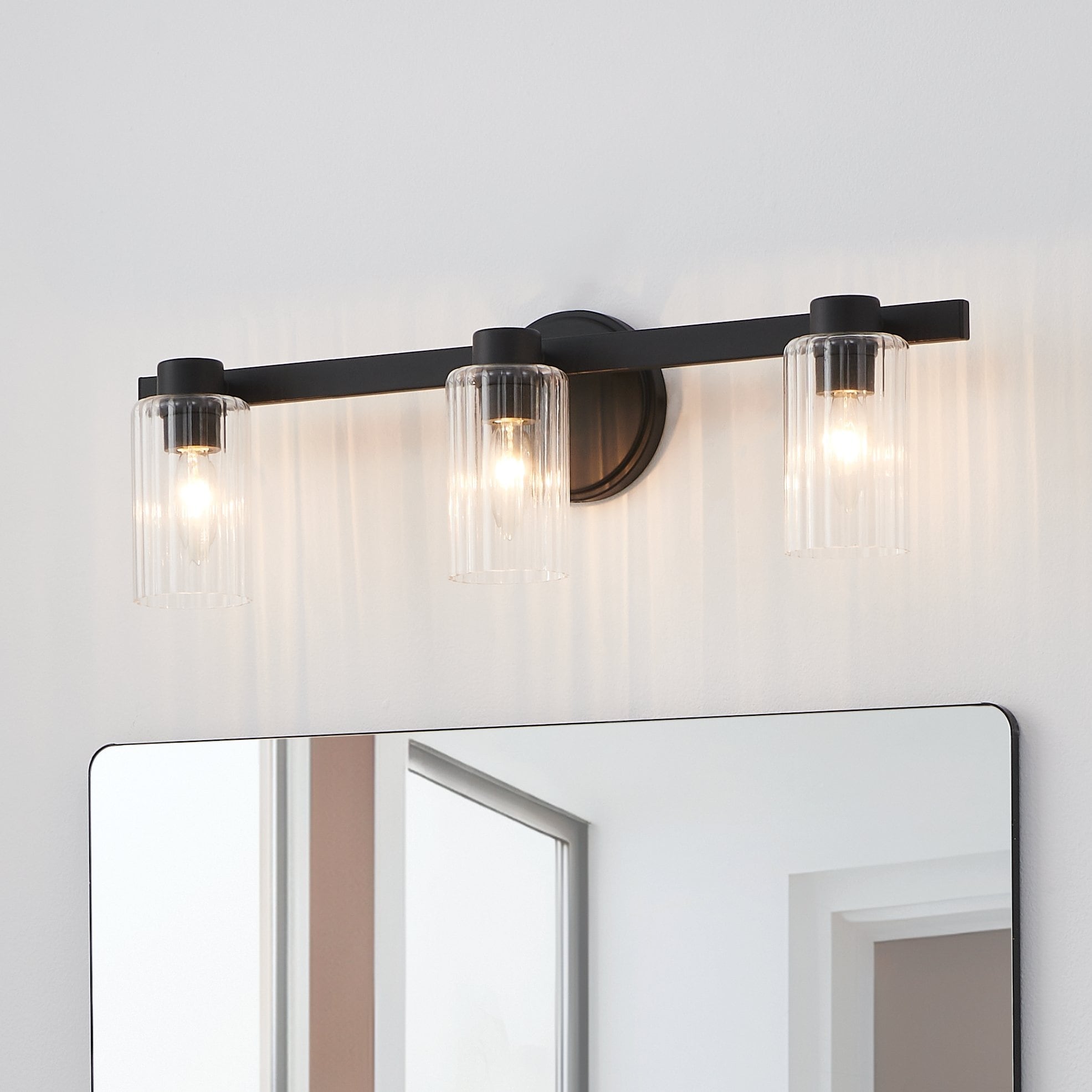 Thesis Bedminster 24-inch 3-light Matte Black Vanity Light with Clear Ribbed Glass Shades