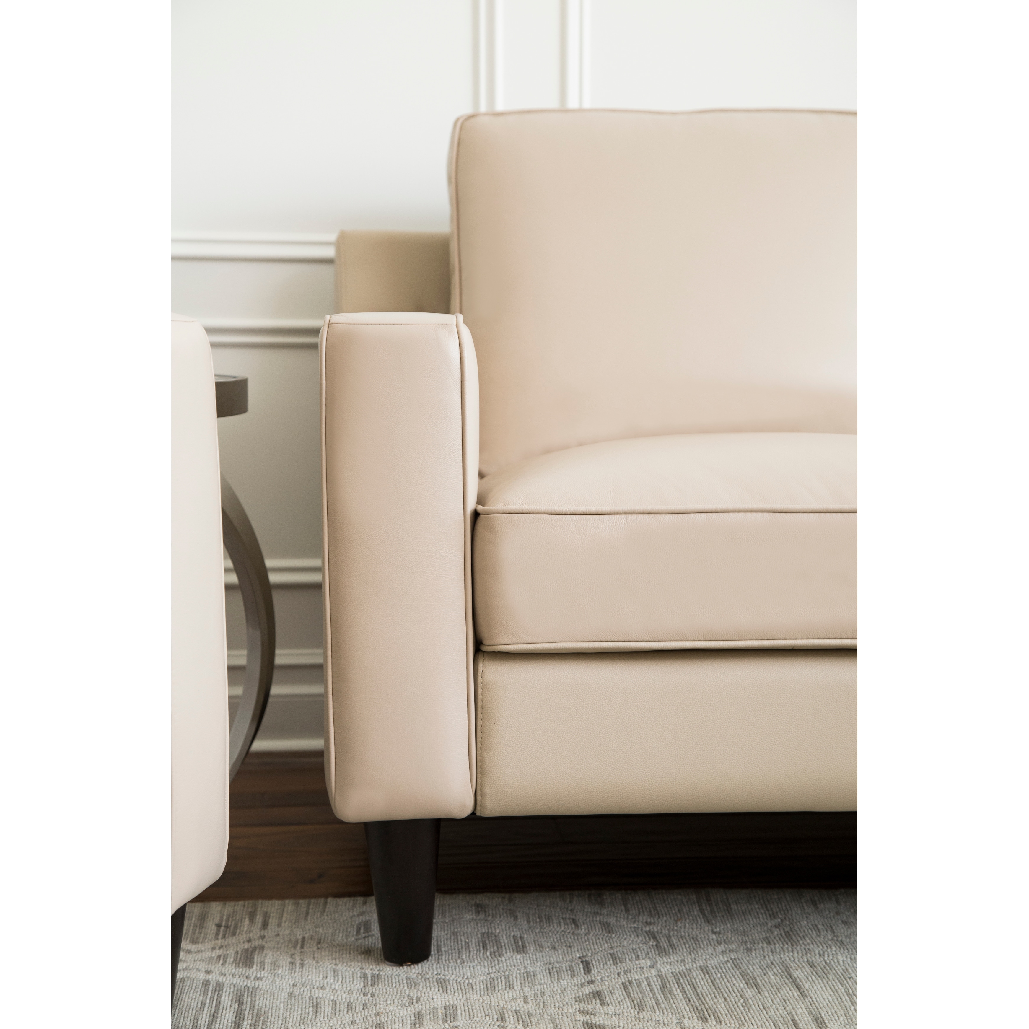 Close-up of beige top grain leather armchair upholstery detail.