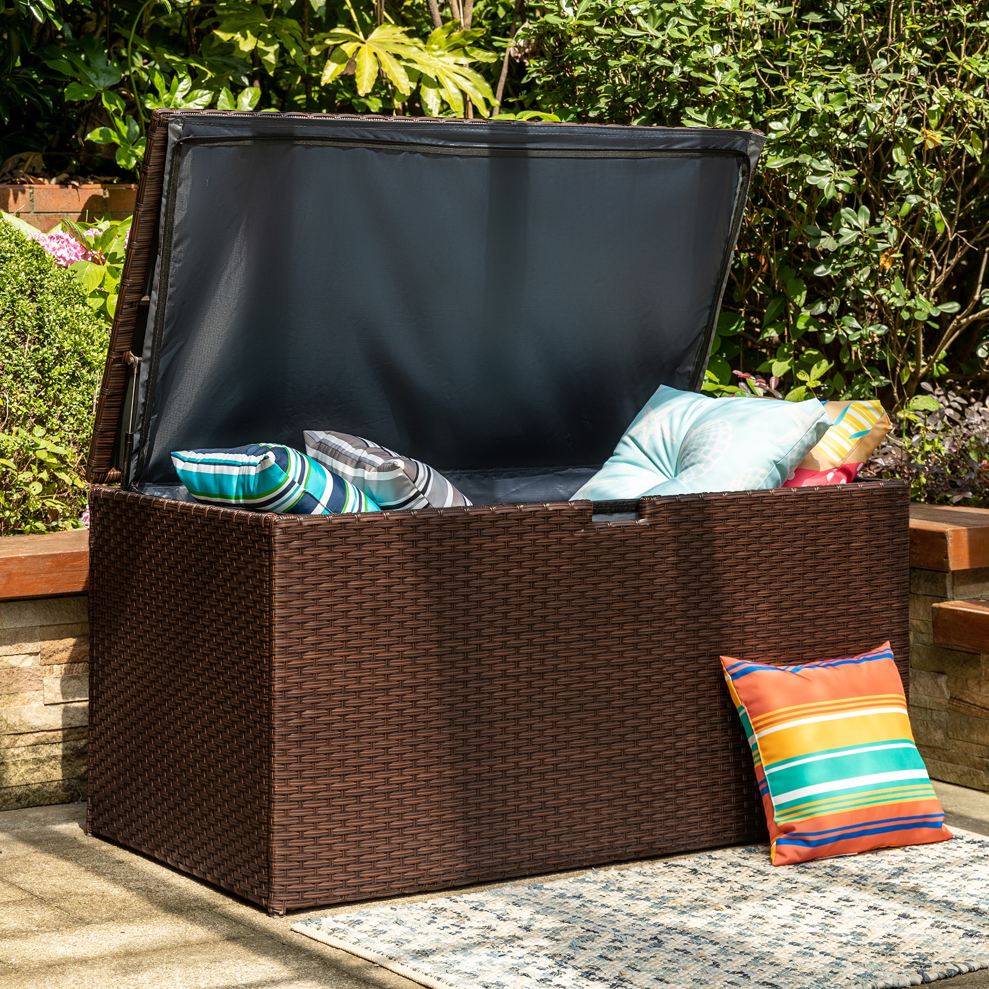 Outdoor wicker storage bench with outlet cushion