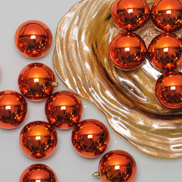 A sweet tree with blue, orange and red ornaments and bows ...