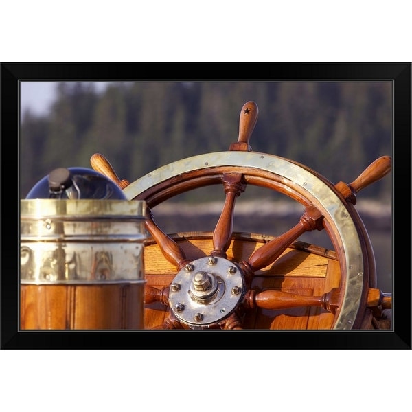 "A warm glow highlights the ship's wheel and compass on a classic sailing yacht" Black Framed Print