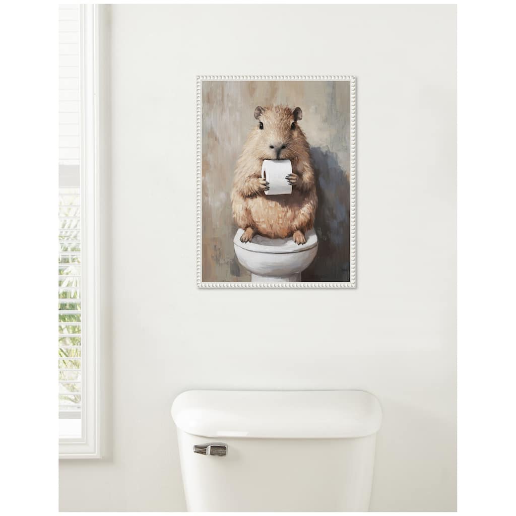 Kate and Laurel Sylvie Capybara Holding Toilet Paper Roll Toilet Bathroom Art Framed Canvas by The Creative Bunch Studio