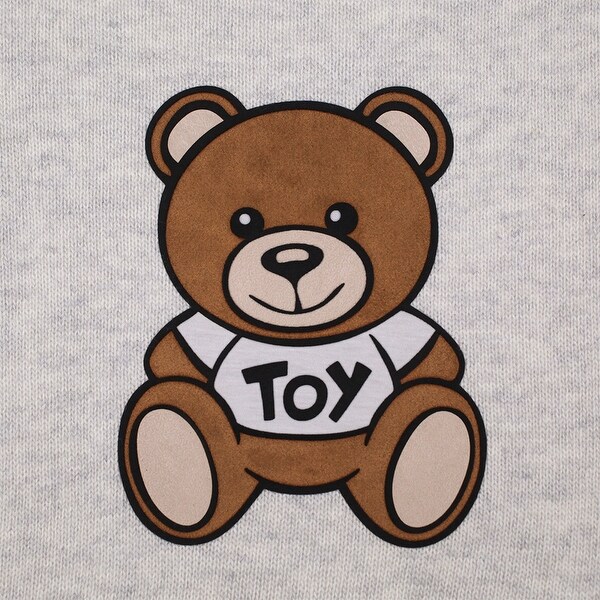 grey teddy bear with patches