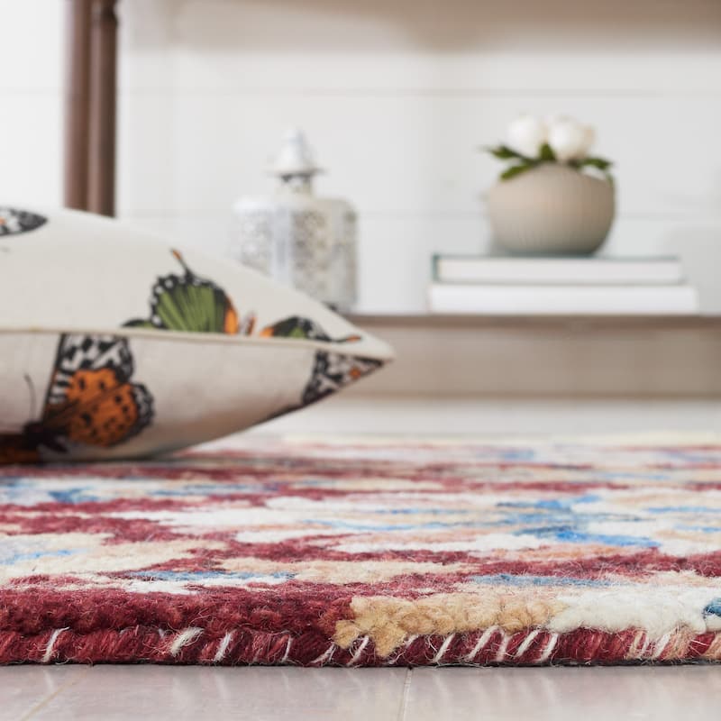 SAFAVIEH Handmade Aspen Orane Floral Braided Tassel Wool Rug