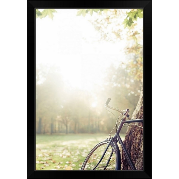 "Bicycle leaned on tree in autumn light." Black Framed Print