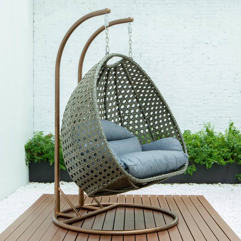 LeisureMod 2-Person Hanging Egg Swing Chair with Metal Stand - Handcrafted Beige Wicker, Patio Hammock Lounger with Cushions