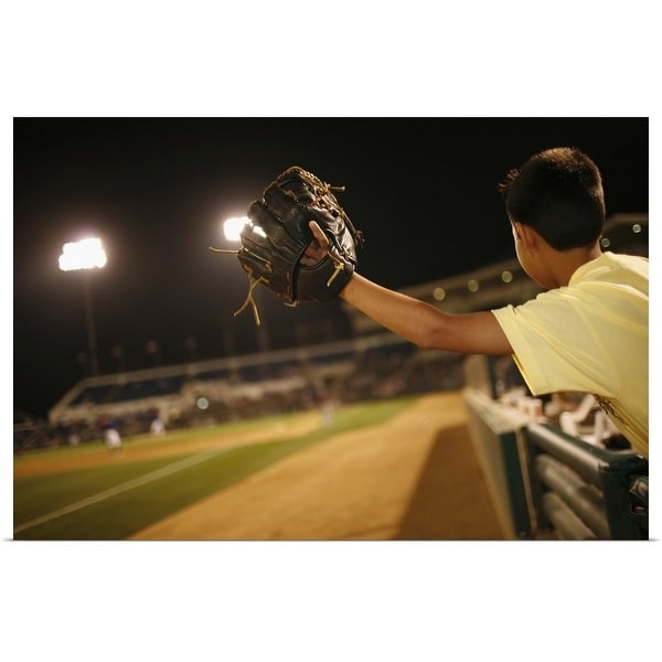 "Kid leaning over wall to try and catch 'foul 'ball at nighttime baseball game" Poster Print