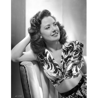 Carol Forman in a Printed Dress sitting and Leaning on Chair Photo ...