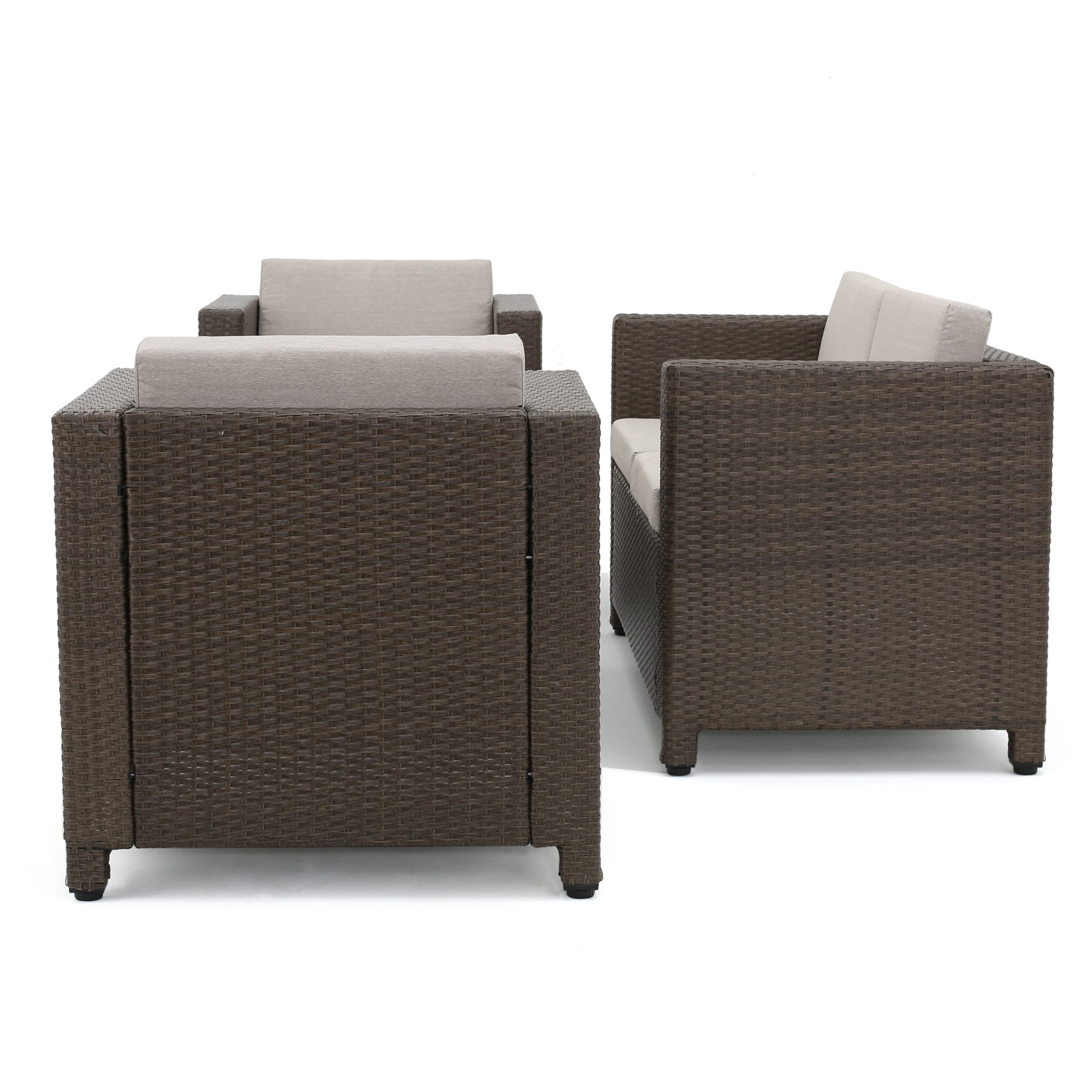 Back view of brown wicker outdoor furniture with beige cushions, four-seat sofa and chairs