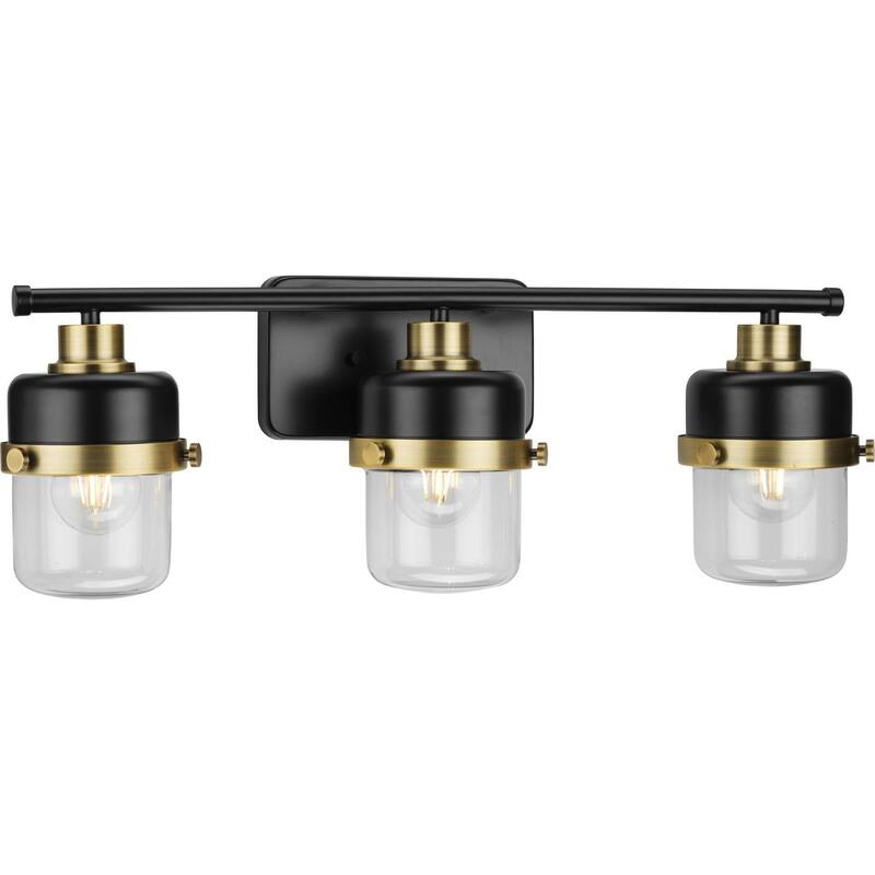 Beckner Collection Three-Light Matte Black Clear Glass Urban Industrial Bath Light with Vintage Brass Accents - 24.12 in x 6.37 in x 8.37 in