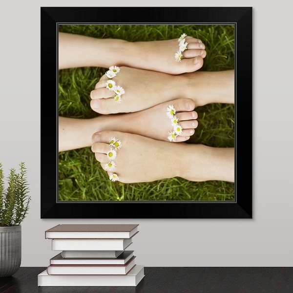 "Close up of daisies on children's toes" Black Framed Print