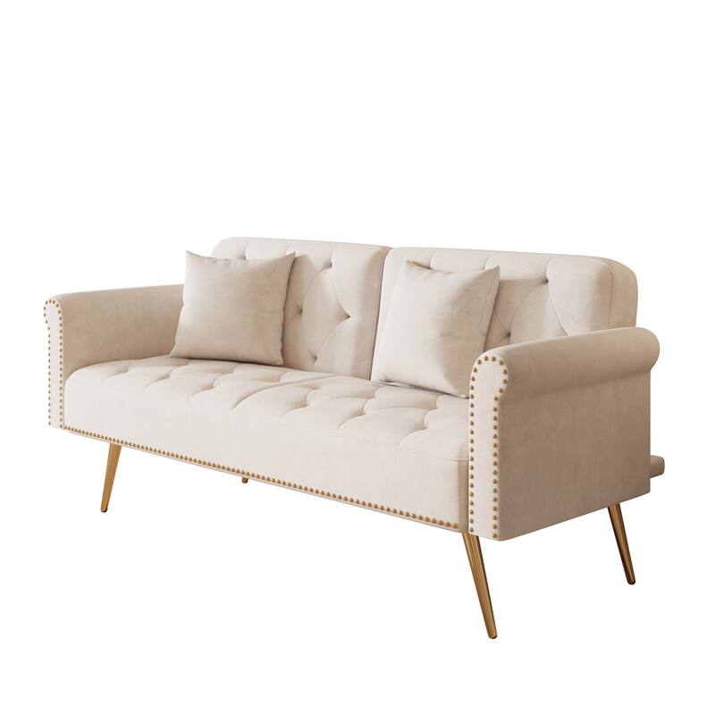 A 69.7-inch-long sofa bed covered in beige velvet fabric, featuring nail head trim and accompanied by a matching throw pillow