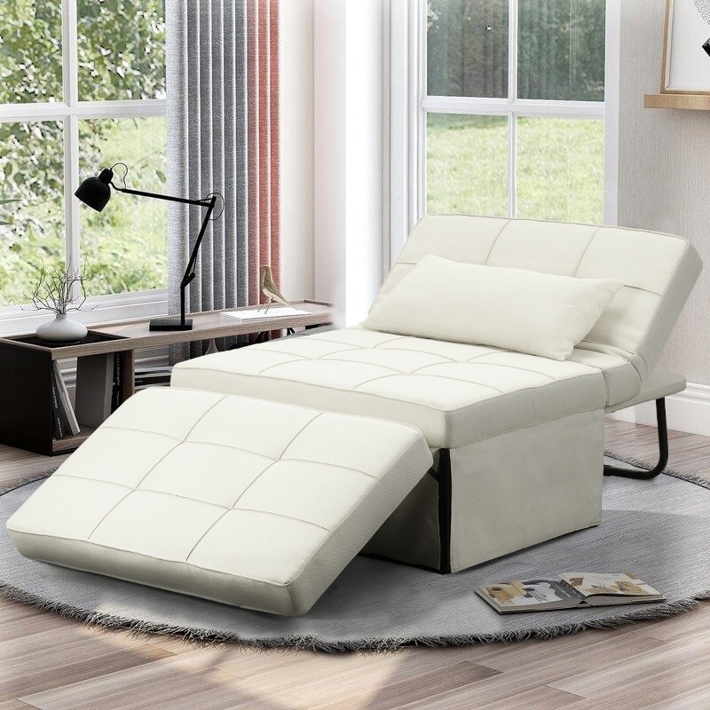 A navy blue tufted futon sofa with pull-out ottoman in a living room