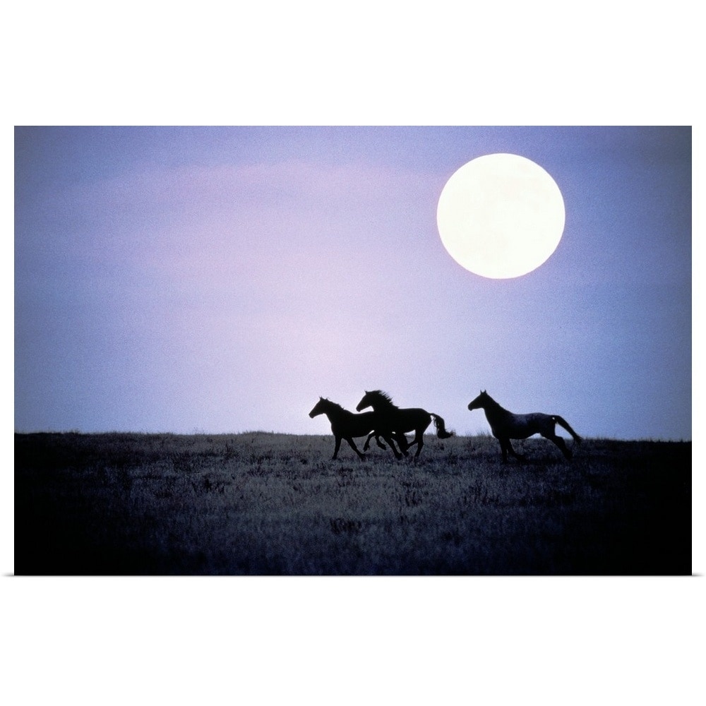 Silhouette of wild horses running in field at dusk with moon