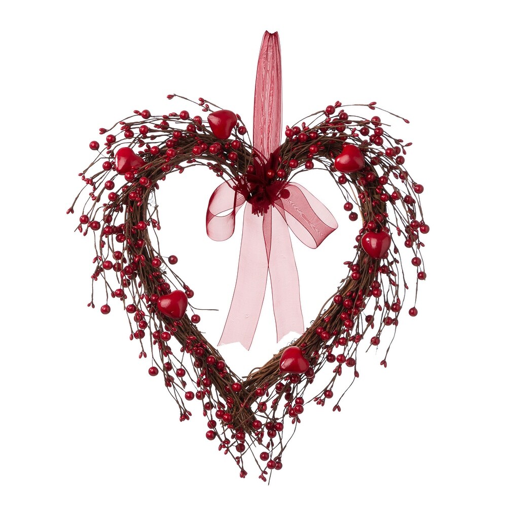 Heart shaped wreath made of branches with berries on them.