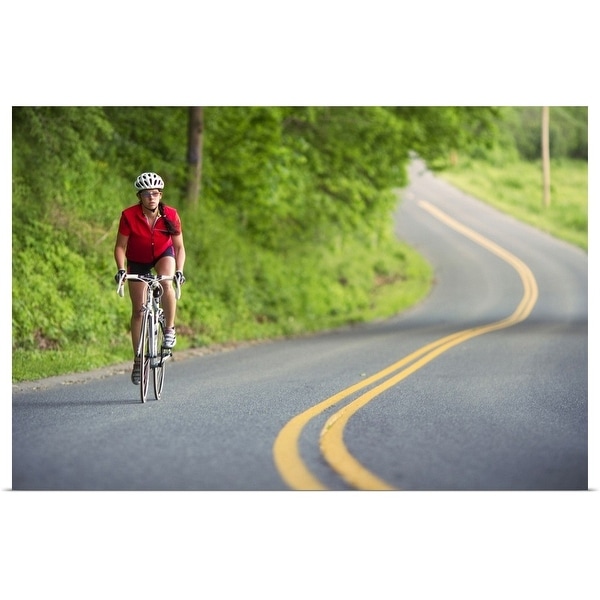 "A female cyclist rides along a country road" Poster Print